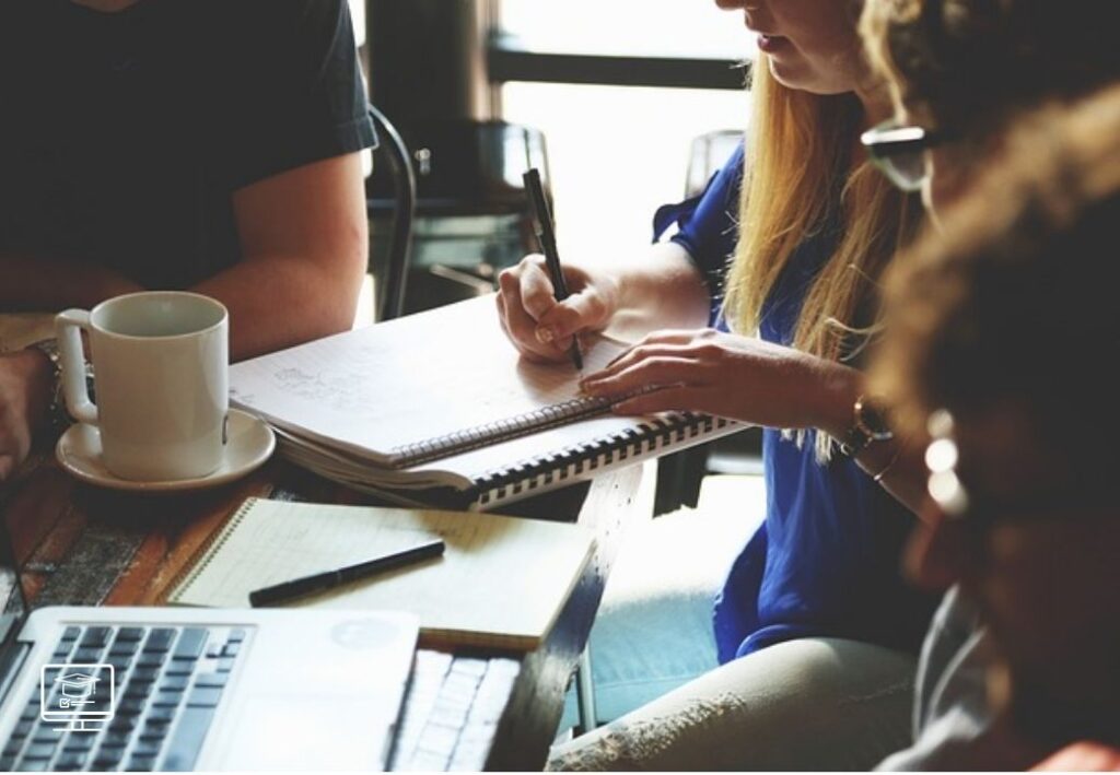 uma mulher auxiliar administrativo fazendo anotação em um caderno em cima da mesa